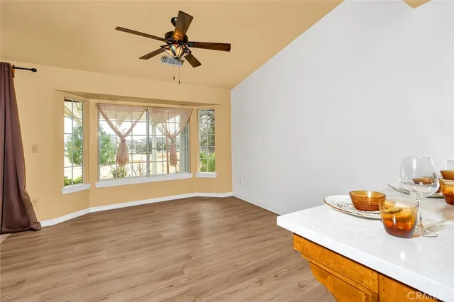 a view of room with wooden floor and a ceiling fan
