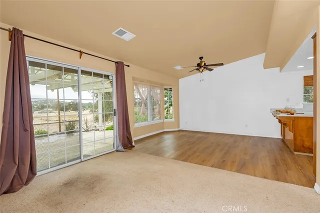 a view of a livingroom with wooden floor and a ceiling fan