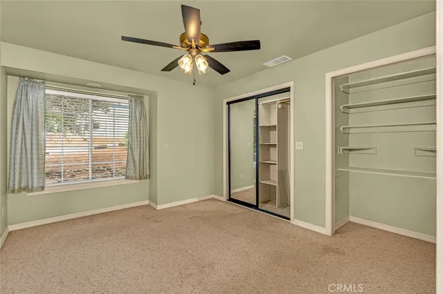 an empty room with closet and windows