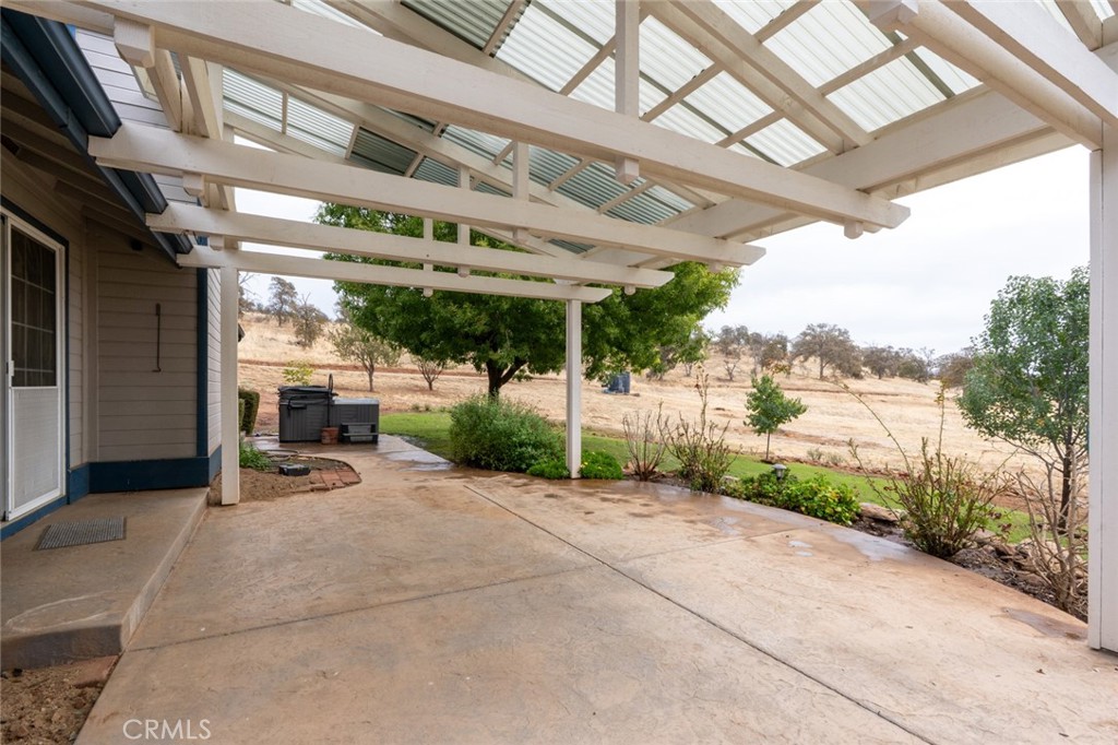 5030 Creek Front Road Catheys Valley, CA 95306 - Photo 38 of 69 a view of a patio with table and chairs and a large tree