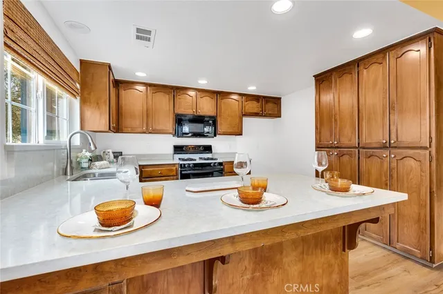 a kitchen with a sink a stove and chairs