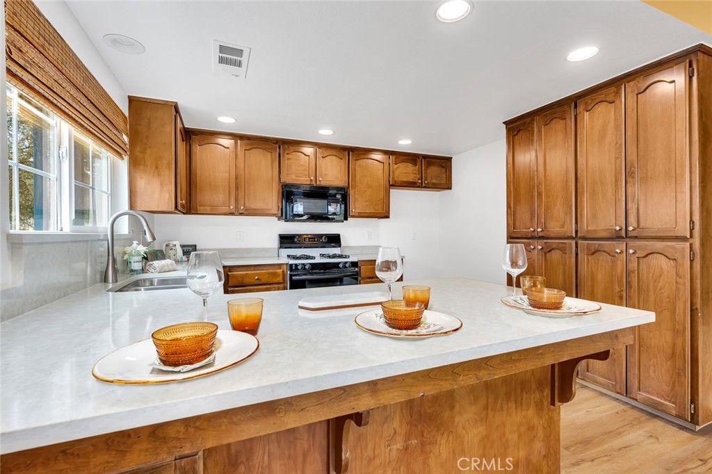 5030 Creek Front Road Catheys Valley, CA 95306 - Photo 9 of 69 a kitchen with a sink a stove and chairs