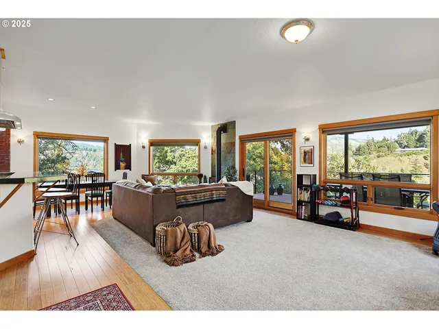 a living room with furniture and a large window with outer view