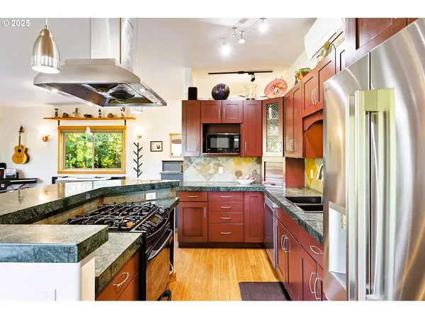 a kitchen with stainless steel appliances granite countertop a refrigerator and a sink