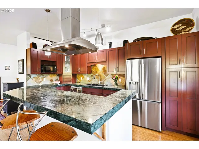 a kitchen with stainless steel appliances kitchen island granite countertop a sink and cabinets