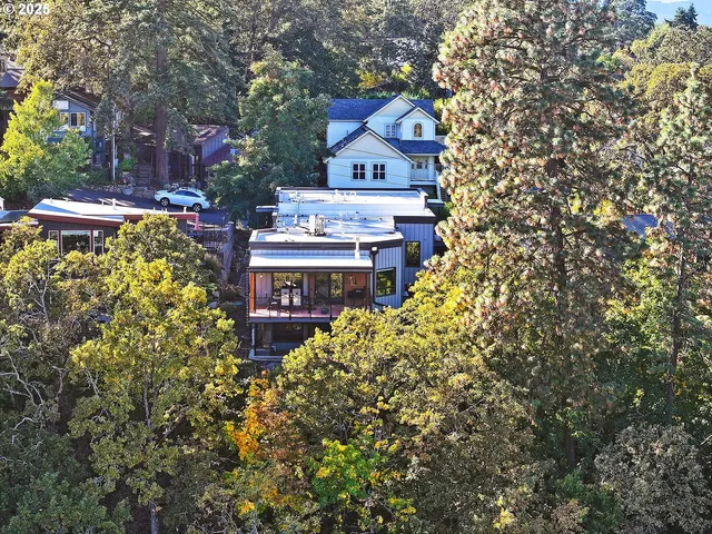 a view of a house with a yard and large trees