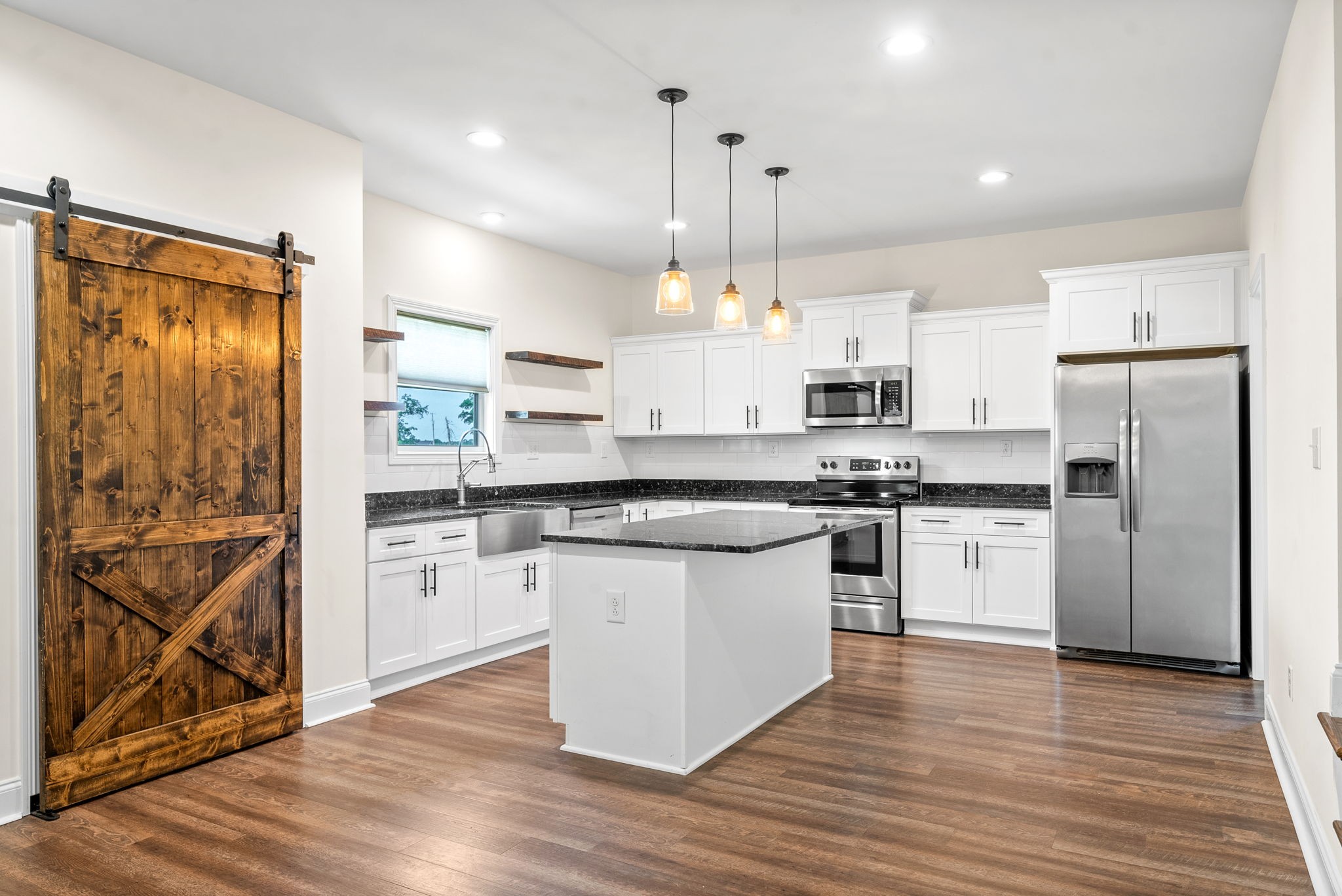 1452 Hickory Point Road Clarksville, TN 37043 - Photo 13 of 38 a kitchen with stainless steel appliances granite countertop a refrigerator a sink dishwasher a stove and white cabinets with wooden floor