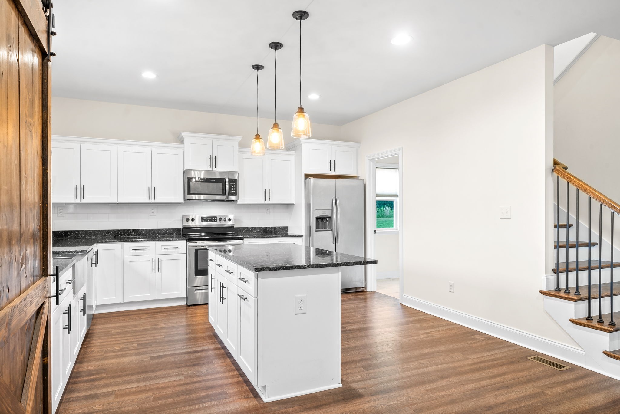1452 Hickory Point Road Clarksville, TN 37043 - Photo 14 of 38 a kitchen with stainless steel appliances a stove top oven a sink a refrigerator and white cabinets with wooden floor