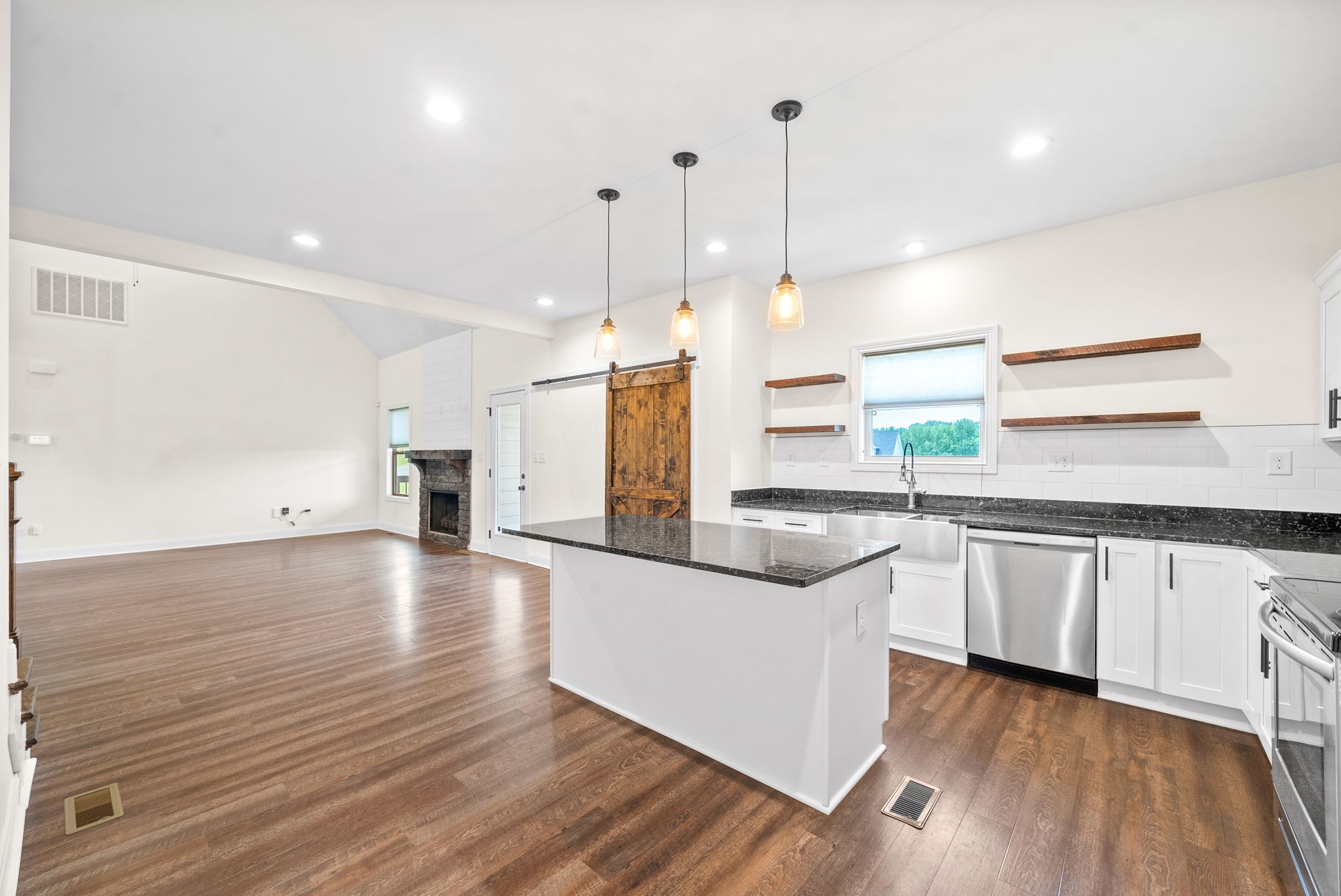 1452 Hickory Point Road Clarksville, TN 37043 - Photo 15 of 38 a kitchen with stainless steel appliances granite countertop wooden floors sink and white cabinets