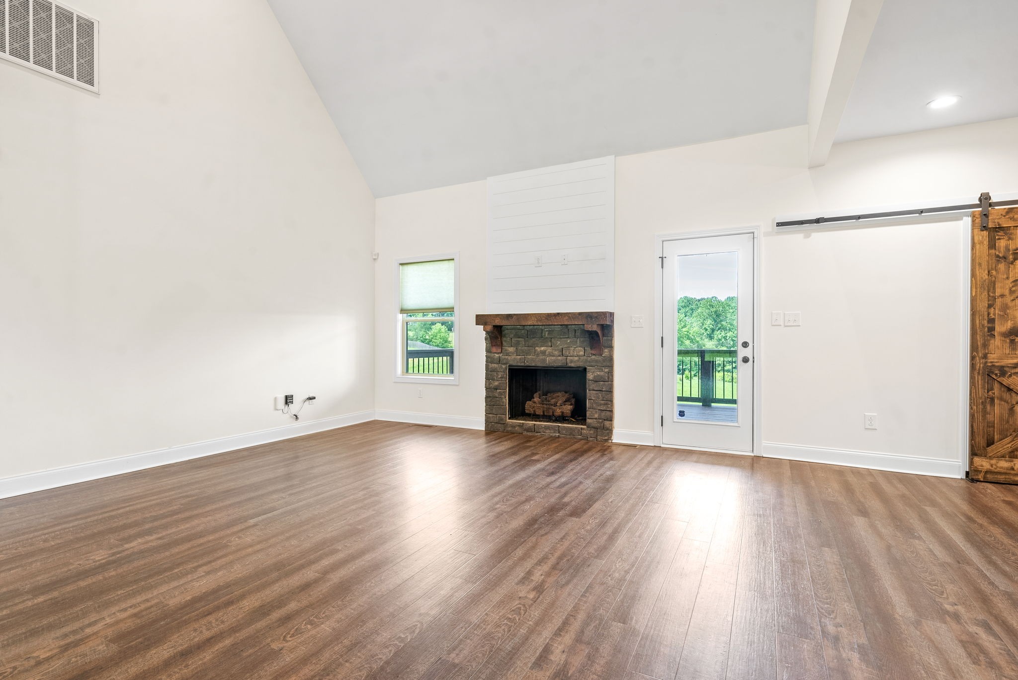 1452 Hickory Point Road Clarksville, TN 37043 - Photo 7 of 38 a view of an empty room with wooden floor fireplace and a window