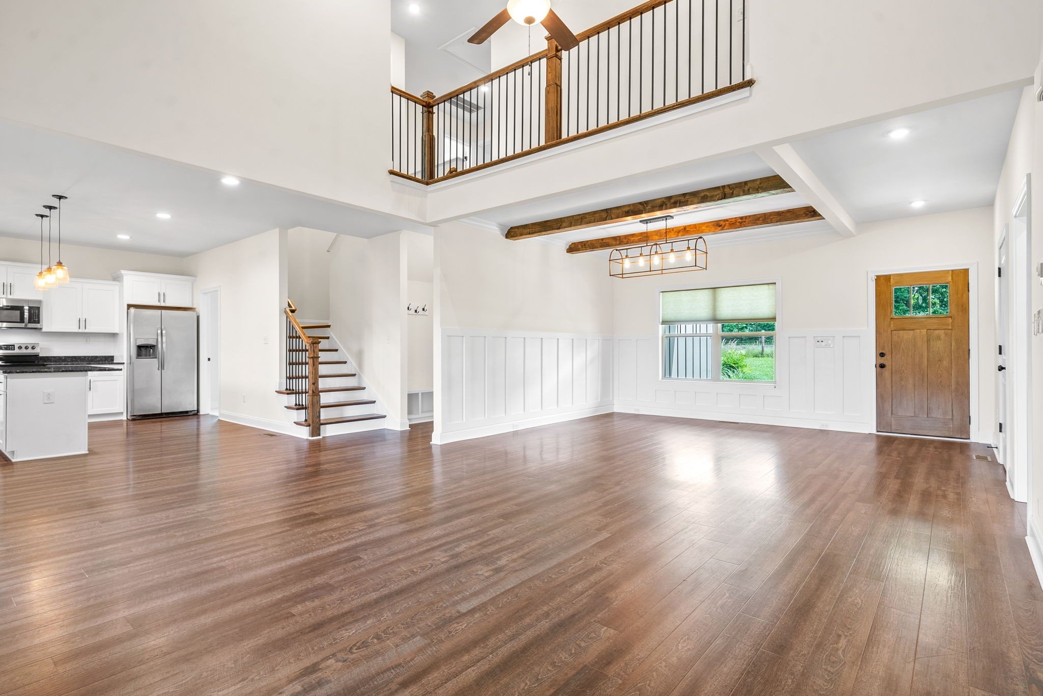 1452 Hickory Point Road Clarksville, TN 37043 - Photo 10 of 38 an empty room with wooden floor windows and kitchen view