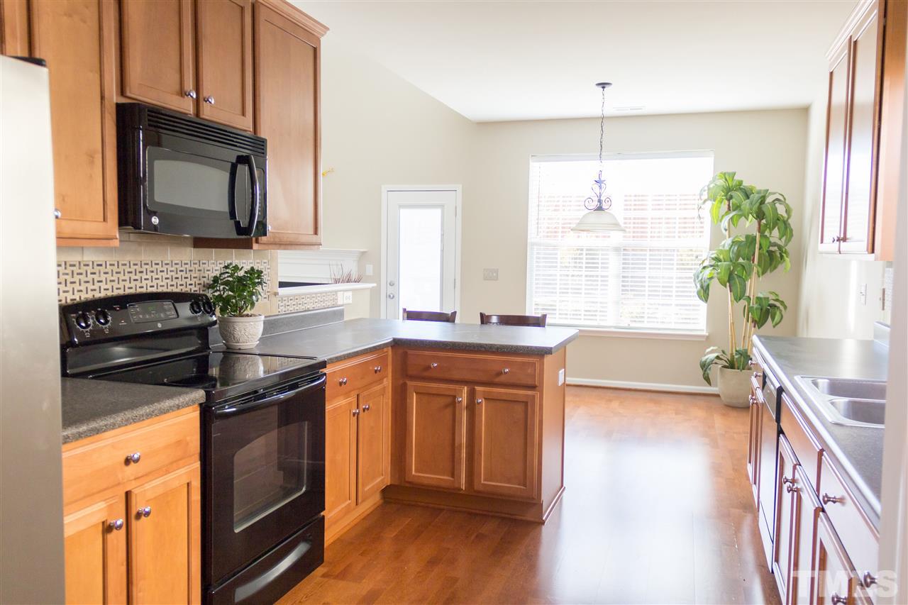 203 Hope Valley Road Knightdale, NC 27545 - Photo 6 of 25 a kitchen with granite countertop a stove a sink and a microwave