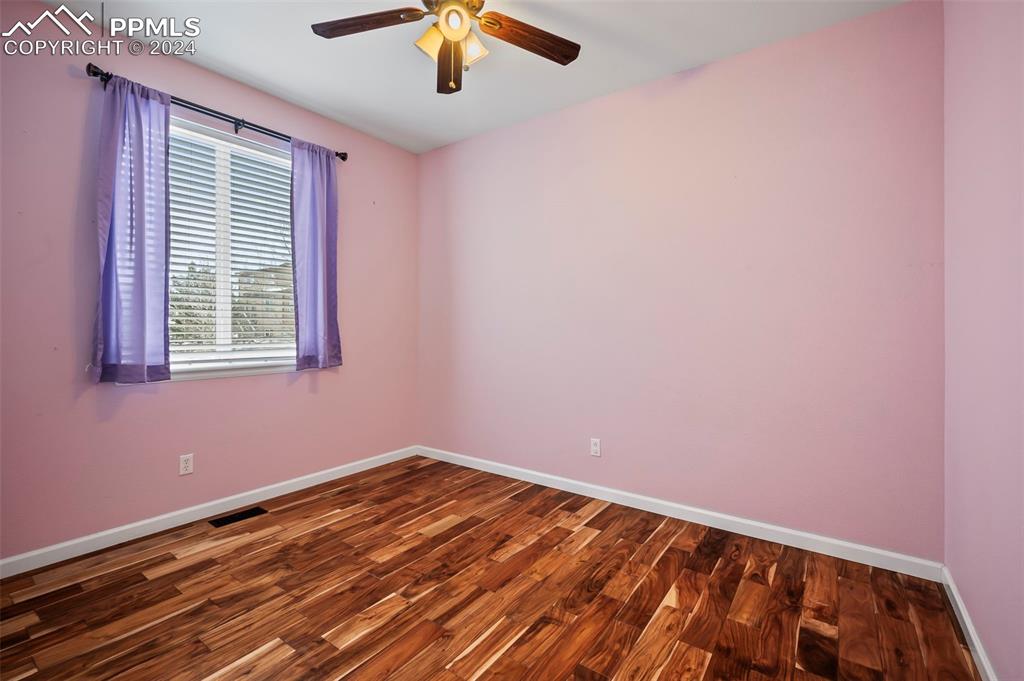 8238 Hollygrape Lane Colorado Springs, CO 80927 - Photo 16 of 35 a view of empty room with wooden floor and fan
