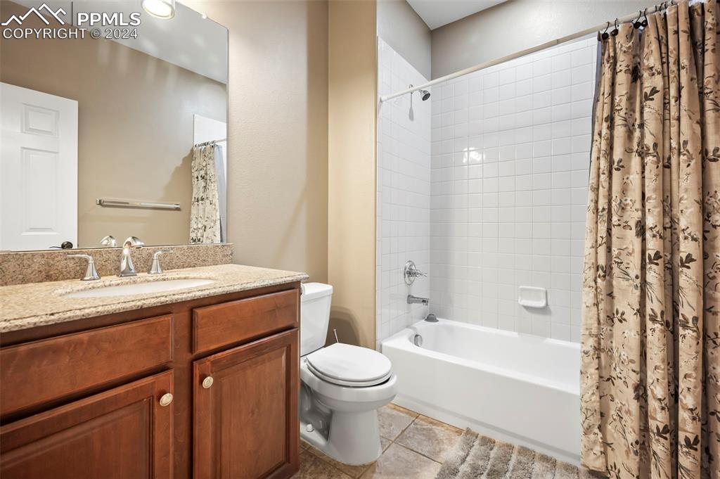 8238 Hollygrape Lane Colorado Springs, CO 80927 - Photo 17 of 35 a bathroom with a granite countertop sink toilet a shower and a mirror