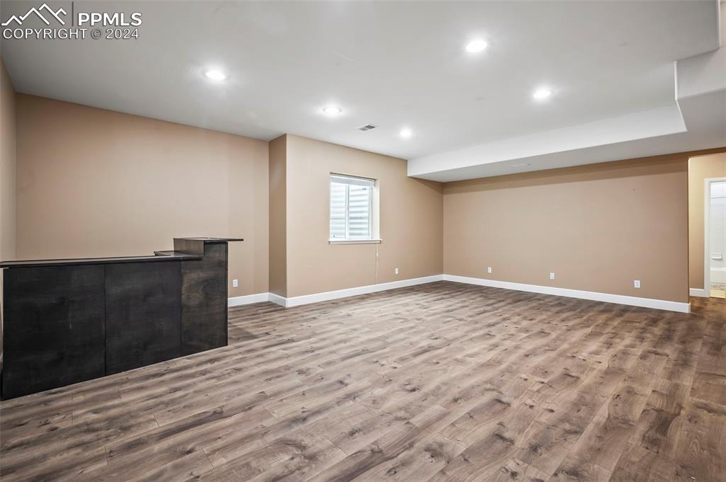 8238 Hollygrape Lane Colorado Springs, CO 80927 - Photo 21 of 35 a view of an empty room with wooden floor and a window