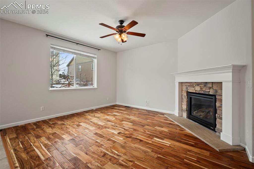 8238 Hollygrape Lane Colorado Springs, CO 80927 - Photo 3 of 35 a view of empty room with wooden floor and fireplace