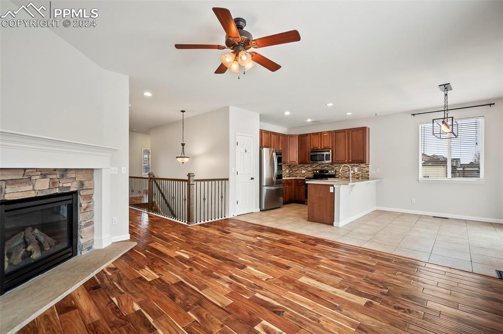8238 Hollygrape Lane Colorado Springs, CO 80927 - Photo 4 of 35 a open kitchen with kitchen island a stove a sink and a refrigerator