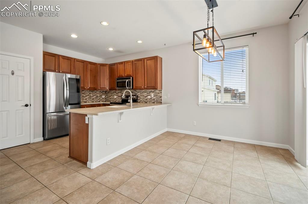 8238 Hollygrape Lane Colorado Springs, CO 80927 - Photo 5 of 35 a kitchen with stainless steel appliances a refrigerator sink and microwave