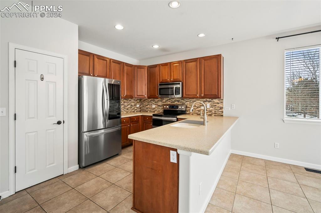8238 Hollygrape Lane Colorado Springs, CO 80927 - Photo 6 of 35 a kitchen with stainless steel appliances granite countertop a refrigerator stove top oven and sink