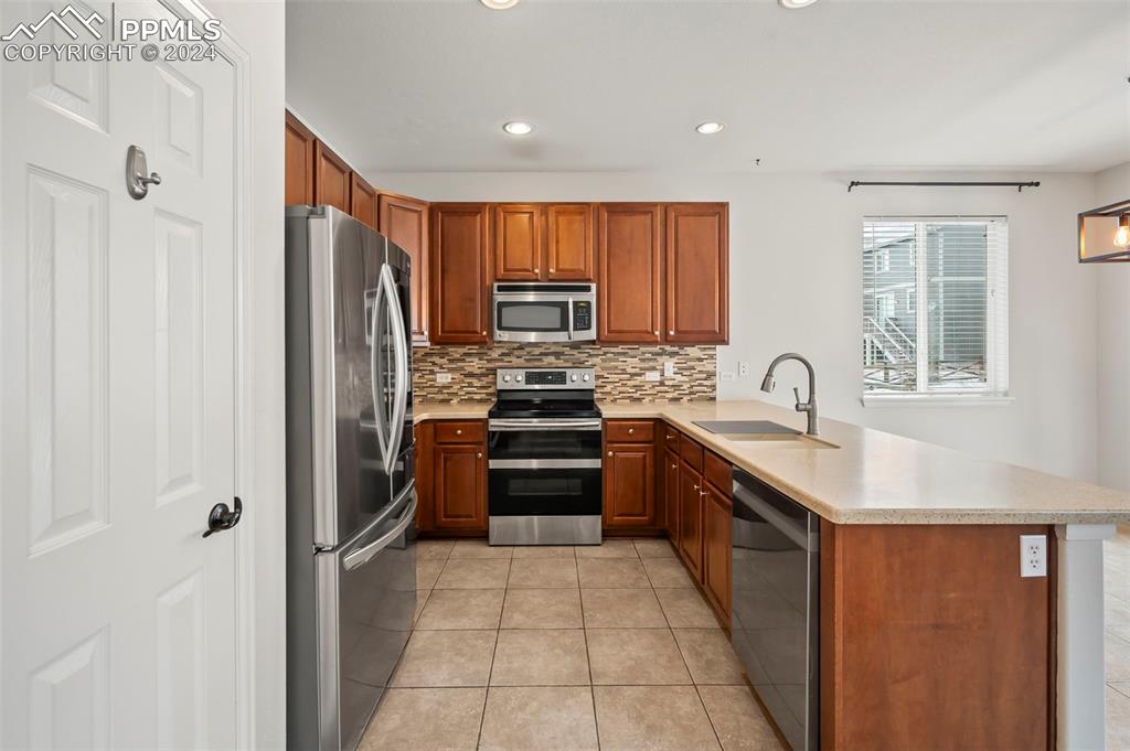 8238 Hollygrape Lane Colorado Springs, CO 80927 - Photo 7 of 35 a kitchen with stainless steel appliances granite countertop a refrigerator stove and sink