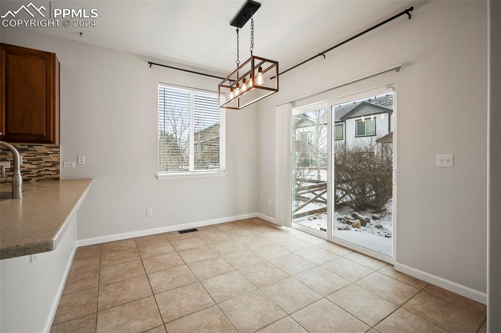 8238 Hollygrape Lane Colorado Springs, CO 80927 - Photo 8 of 35 a view of an empty room with window and chandelier