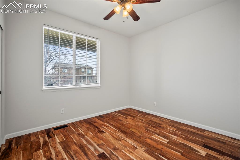 8238 Hollygrape Lane Colorado Springs, CO 80927 - Photo 10 of 35 a view of empty room with wooden floor and windows