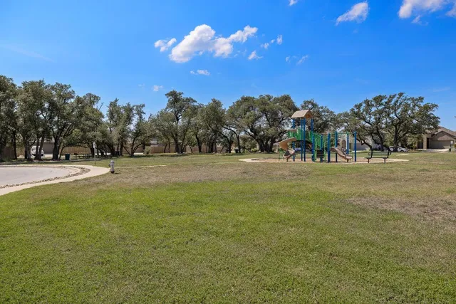 a view of green field with trees in the background