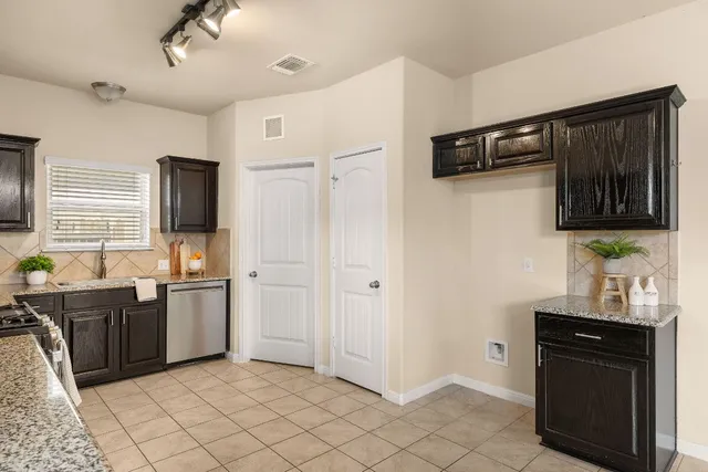 a kitchen with stainless steel appliances granite countertop a refrigerator and a stove top oven