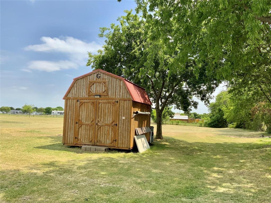 11255 Sam Reynolds Road Justin, TX 76247 - Photo 17 of 19 a view of a tiny house with a big yard and large trees