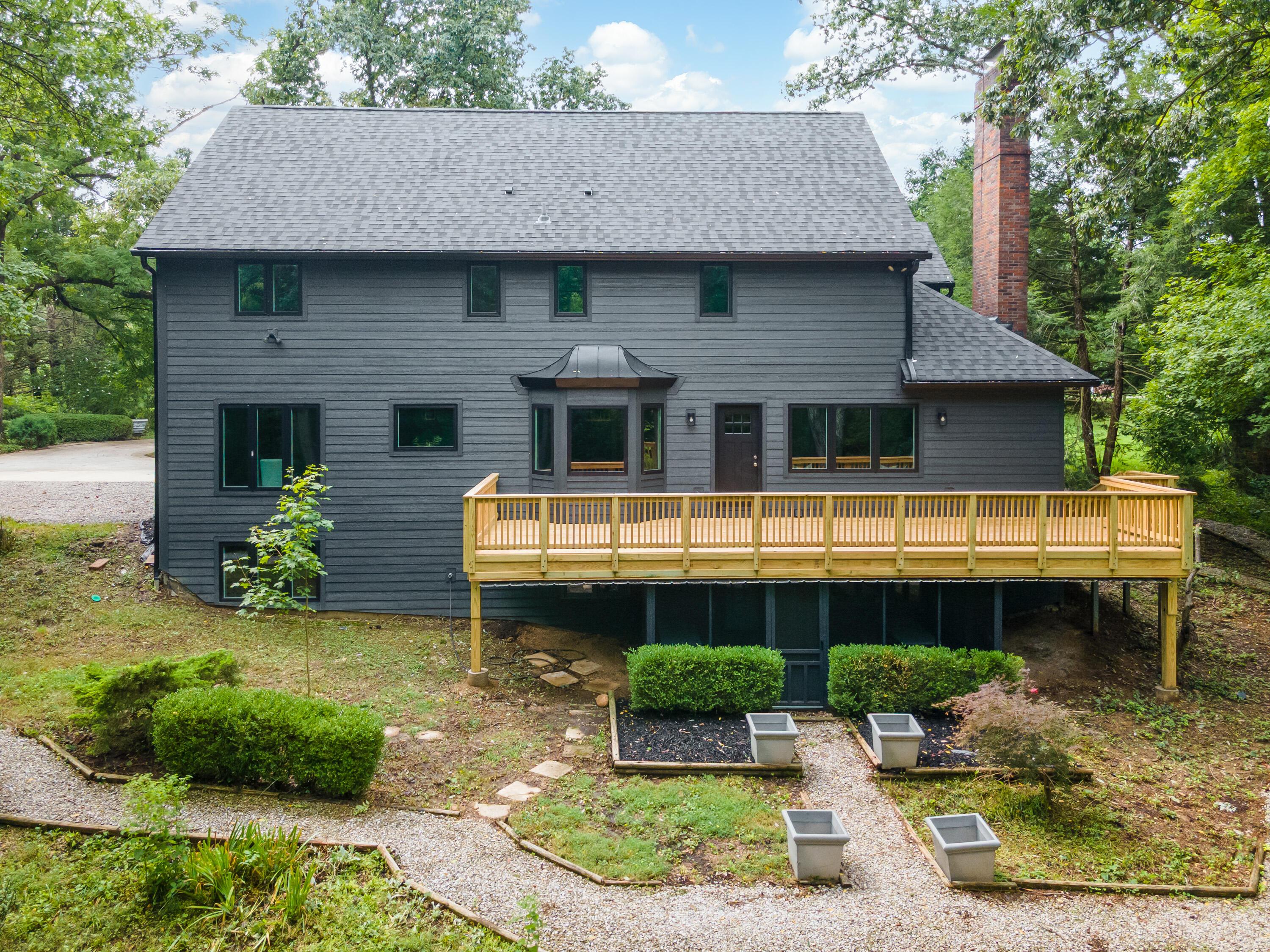 1560 Carriage Road Powell, OH 43065 - Photo 55 of 73 Dark gray exterior siding with a new wood deck, bay window, and a brick chimney