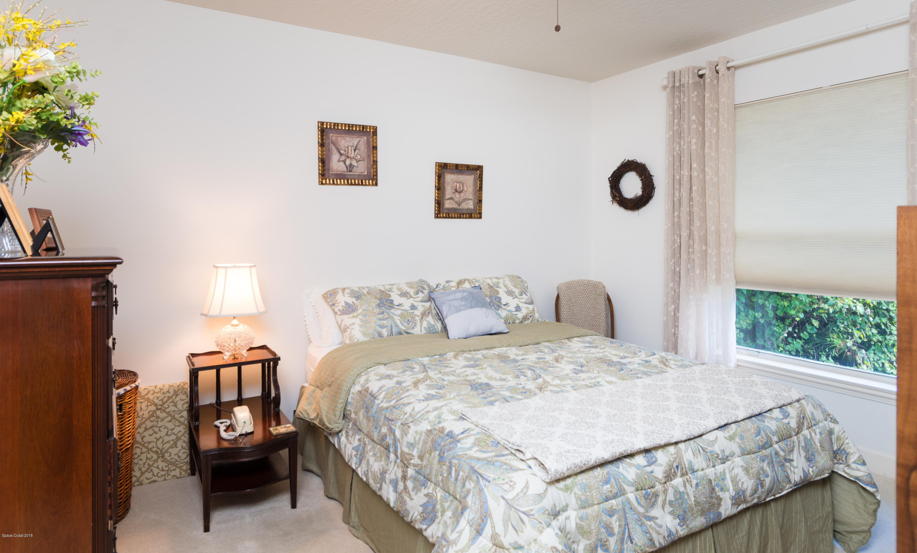 3535 Shady Run Road Melbourne, FL 32934 - Photo 17 of 30 a bedroom with a bed and a chandelier