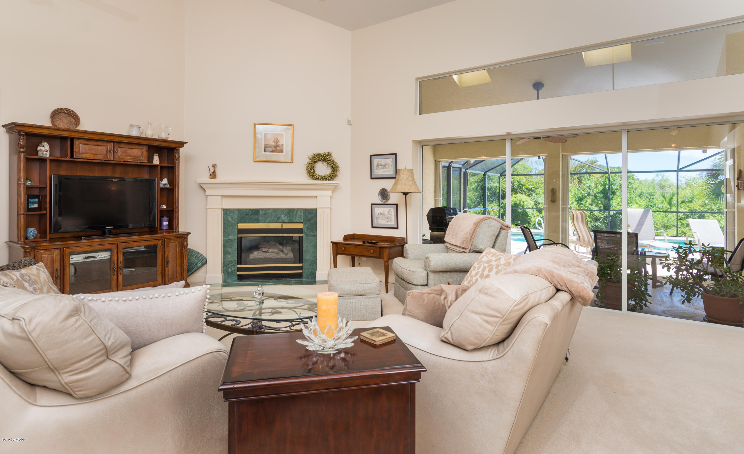 3535 Shady Run Road Melbourne, FL 32934 - Photo 6 of 30 a living room with furniture a flat screen tv and a fireplace