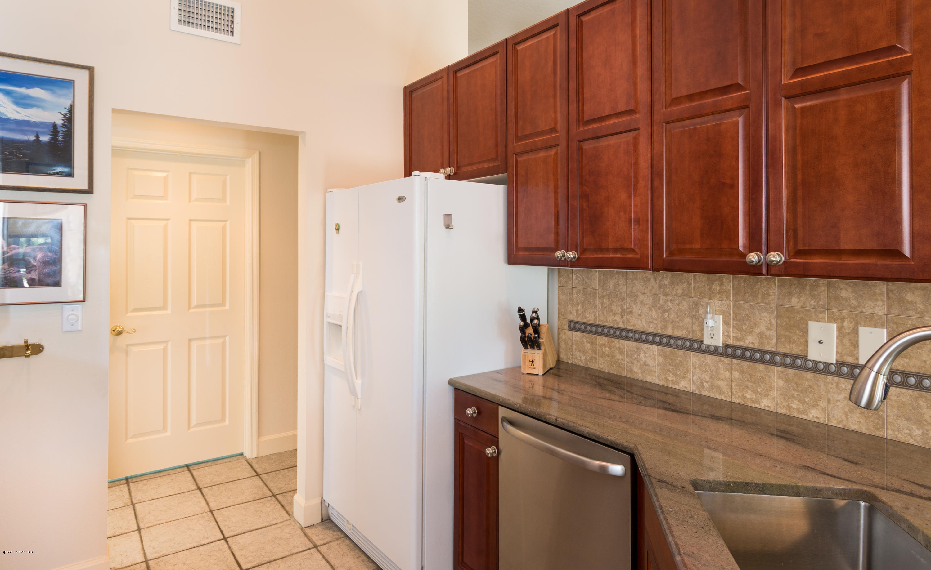 3535 Shady Run Road Melbourne, FL 32934 - Photo 9 of 30 a kitchen with a refrigerator and cabinets