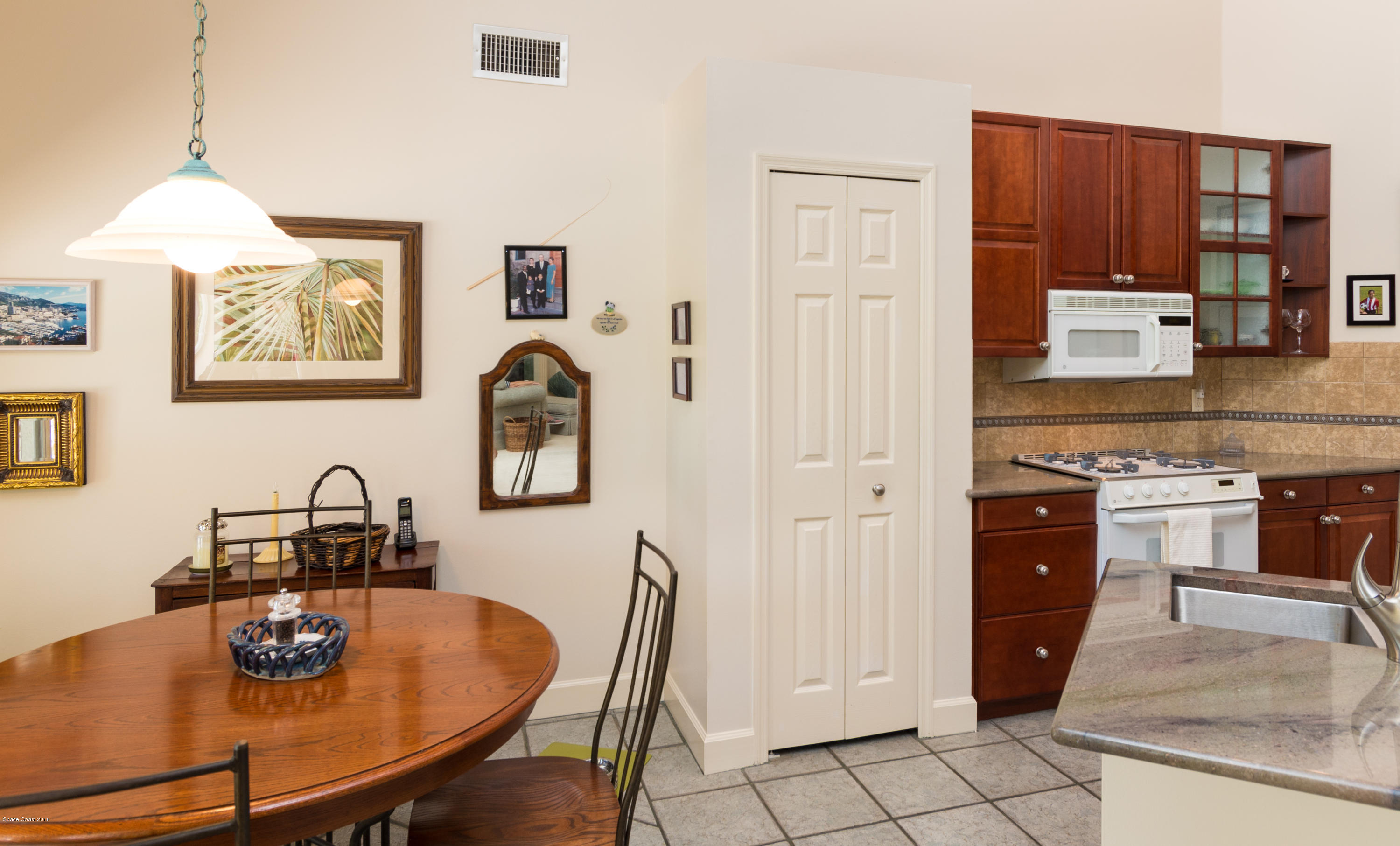 3535 Shady Run Road Melbourne, FL 32934 - Photo 10 of 30 a kitchen with a table chairs and a refrigerator