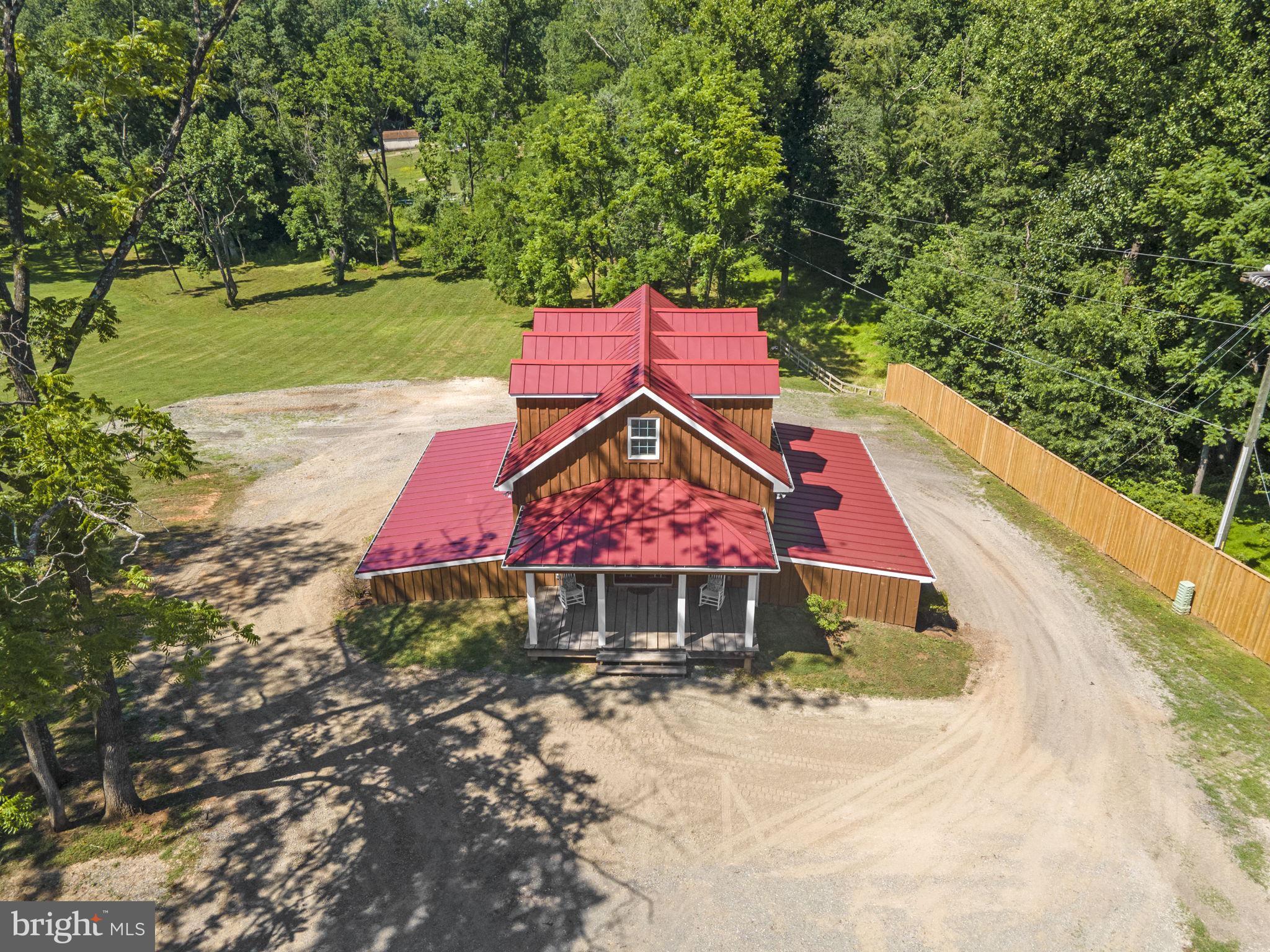 an aerial view of a house with a yard and a large tree