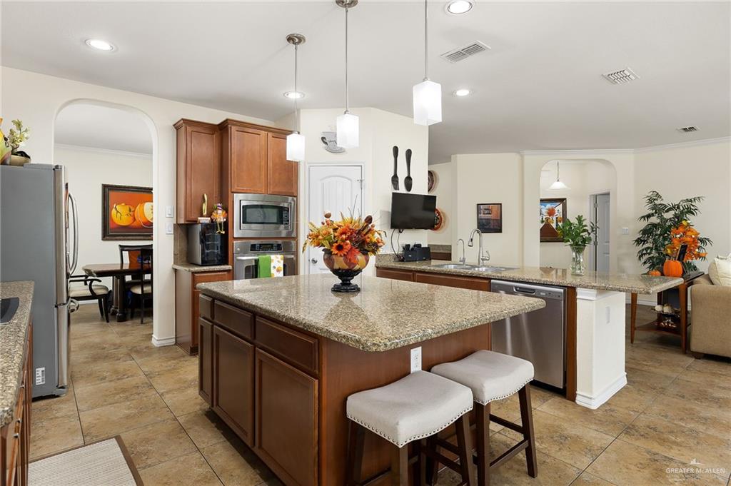 3901 Santa Veronica Street Mission, TX 78572 - Photo 6 of 22 a room with stainless steel appliances kitchen island granite countertop a table chairs and a refrigerator