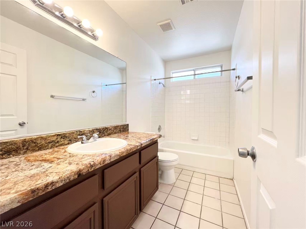 8284 West Rochelle Avenue Las Vegas, NV 89147 - Photo 21 of 29 A well-lit bathroom features a spacious vanity and a tub with clean tile surround.