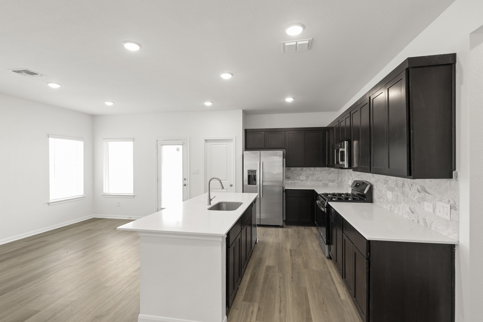 3725 Pin Oak Hills Seguin, TX 78155 - Photo 10 of 21 Kitchen with stainless steel appliances, light wood-style flooring, a kitchen island with sink, light stone counters, and recessed lighting