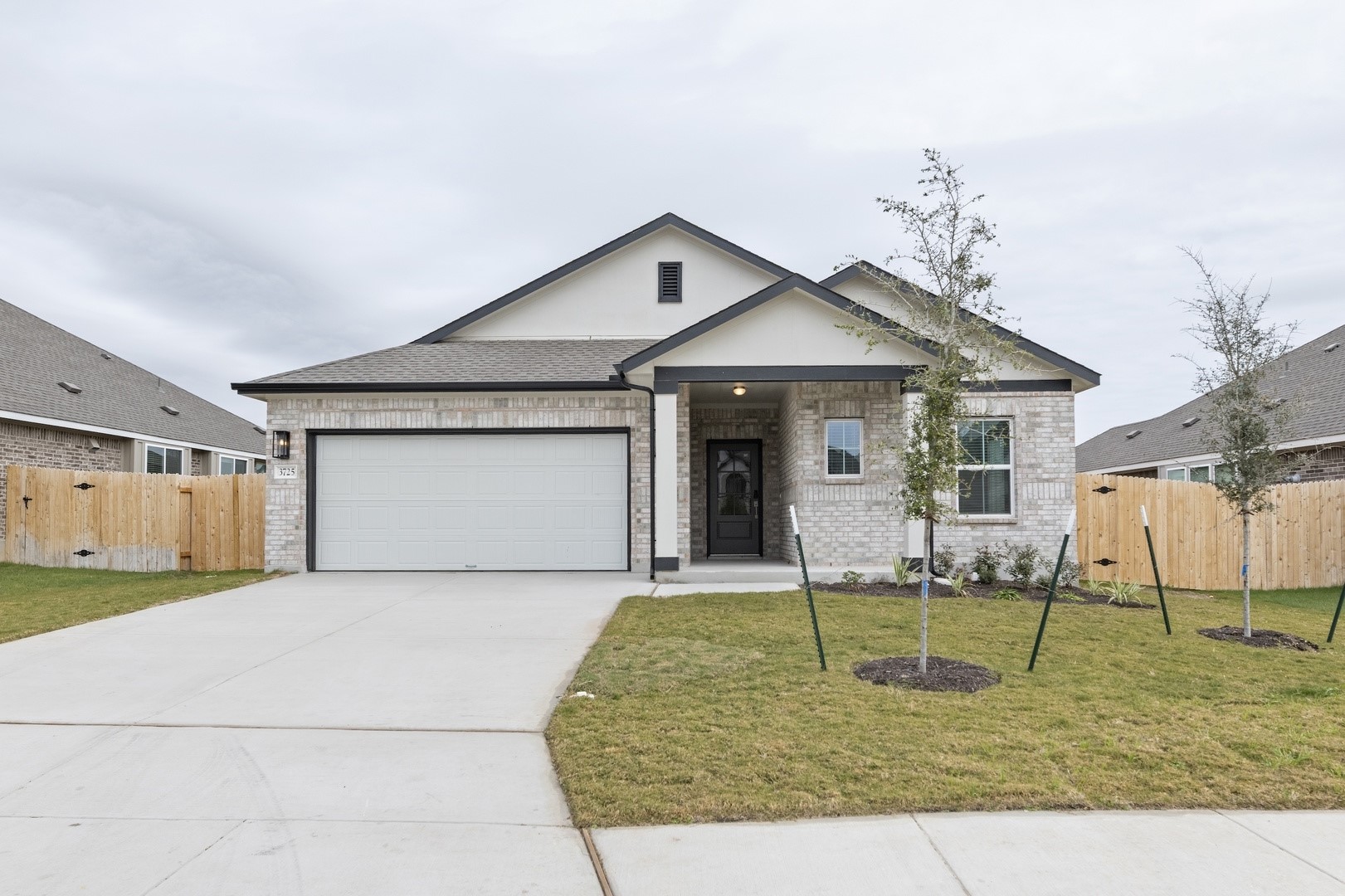 3725 Pin Oak Hills Seguin, TX 78155 - Photo 2 of 21 View of front facade featuring brick siding, concrete driveway, an attached garage, and a gate