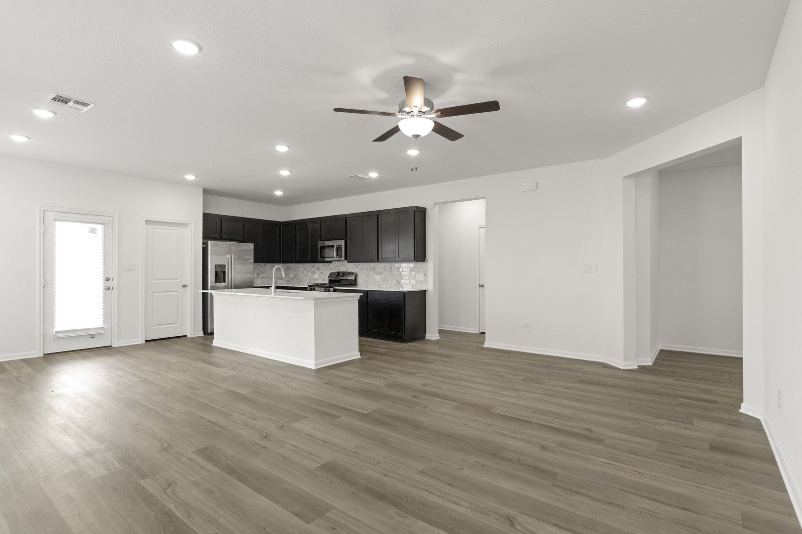 3725 Pin Oak Hills Seguin, TX 78155 - Photo 20 of 21 Kitchen with open floor plan, a kitchen island with sink, ceiling fan, appliances with stainless steel finishes, and light wood-style flooring
