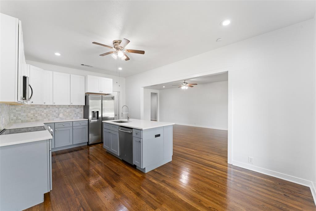 2405 Monroe Street Commerce, TX 75428 - Photo 11 of 31 a kitchen with stainless steel appliances a sink cabinets and wooden floor