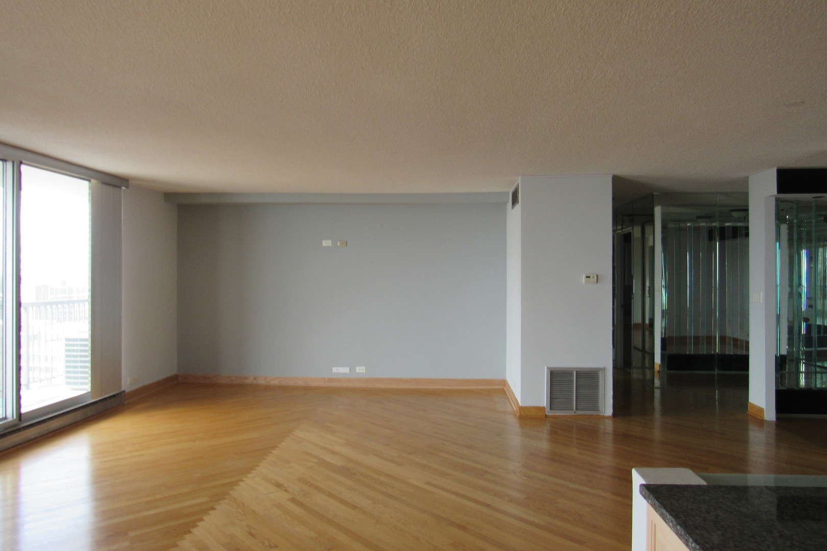 5855 North Sheridan Road, Unit 14CE Chicago, IL 60660 - Photo 5 of 14 wooden floor in an empty room with a window