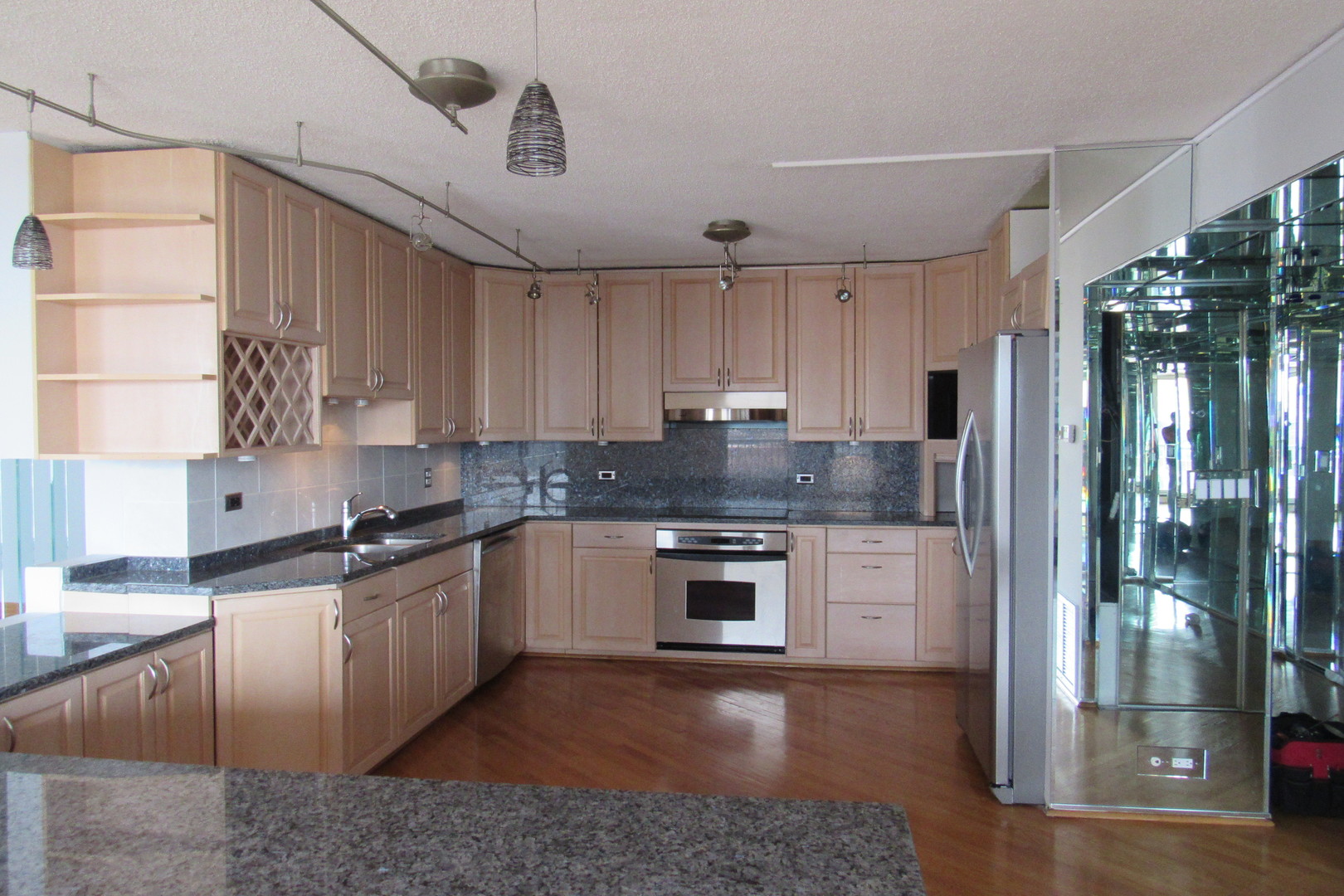 5855 North Sheridan Road, Unit 14CE Chicago, IL 60660 - Photo 8 of 14 a kitchen with stainless steel appliances granite countertop a refrigerator a sink dishwasher a stove and white countertops with cabinets