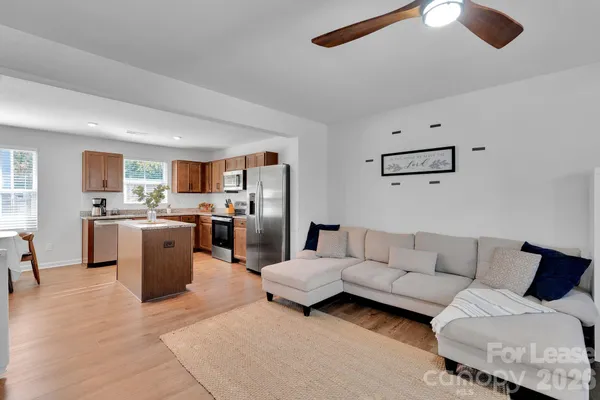a living room with furniture and kitchen view