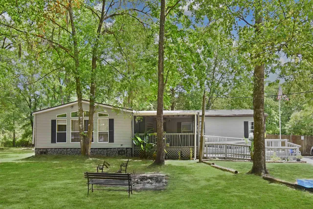 a view of a chair and table in backyard of the house