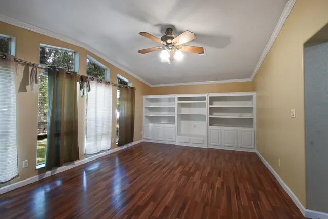 a view of an empty room with wooden floor