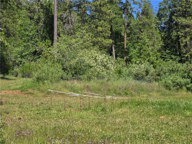 a backyard of a house with table and chairs under an umbrella