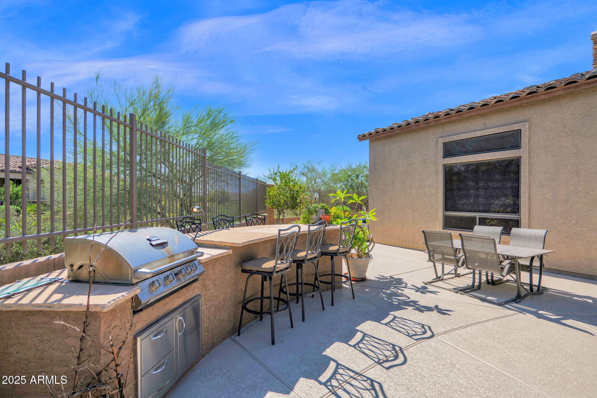 4207 North Arboles Circle Mesa, AZ 85207 - Photo 55 of 71 a table and chairs sitting in front of a house