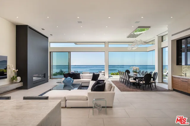 a living room with fireplace furniture and a large window