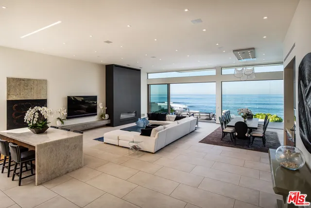 a living room with fireplace furniture and a large window